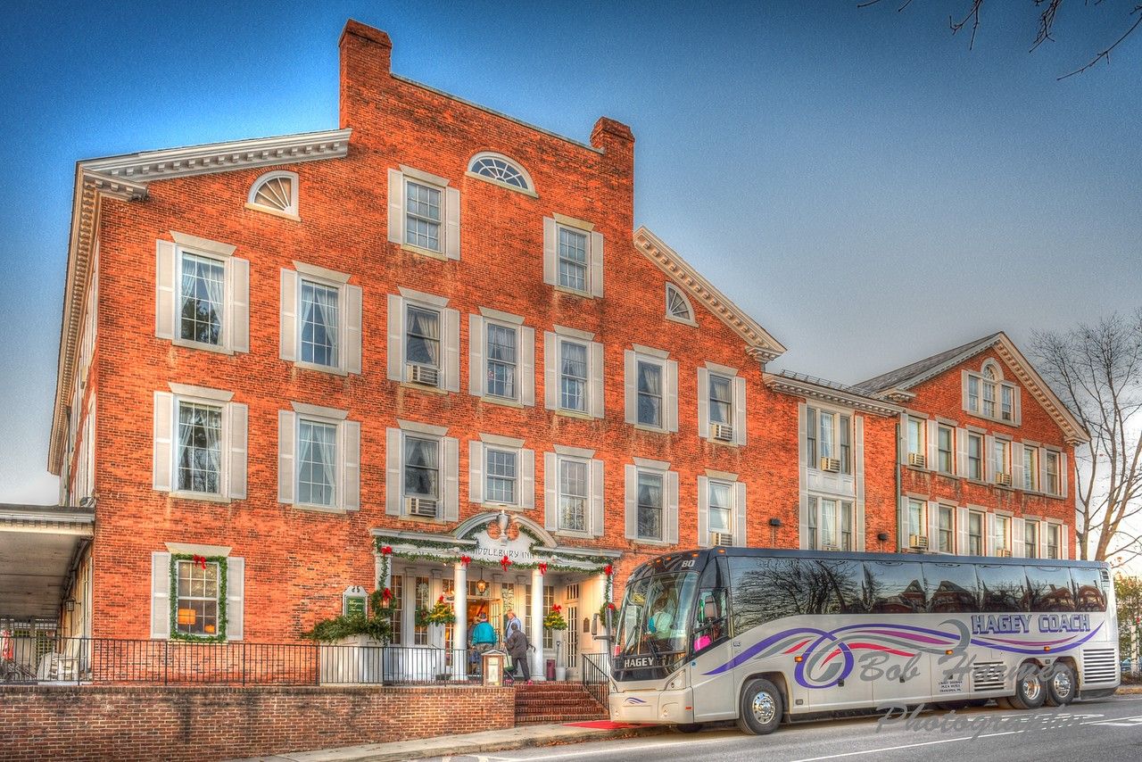 A large tour bus is parked outside of the Inn.